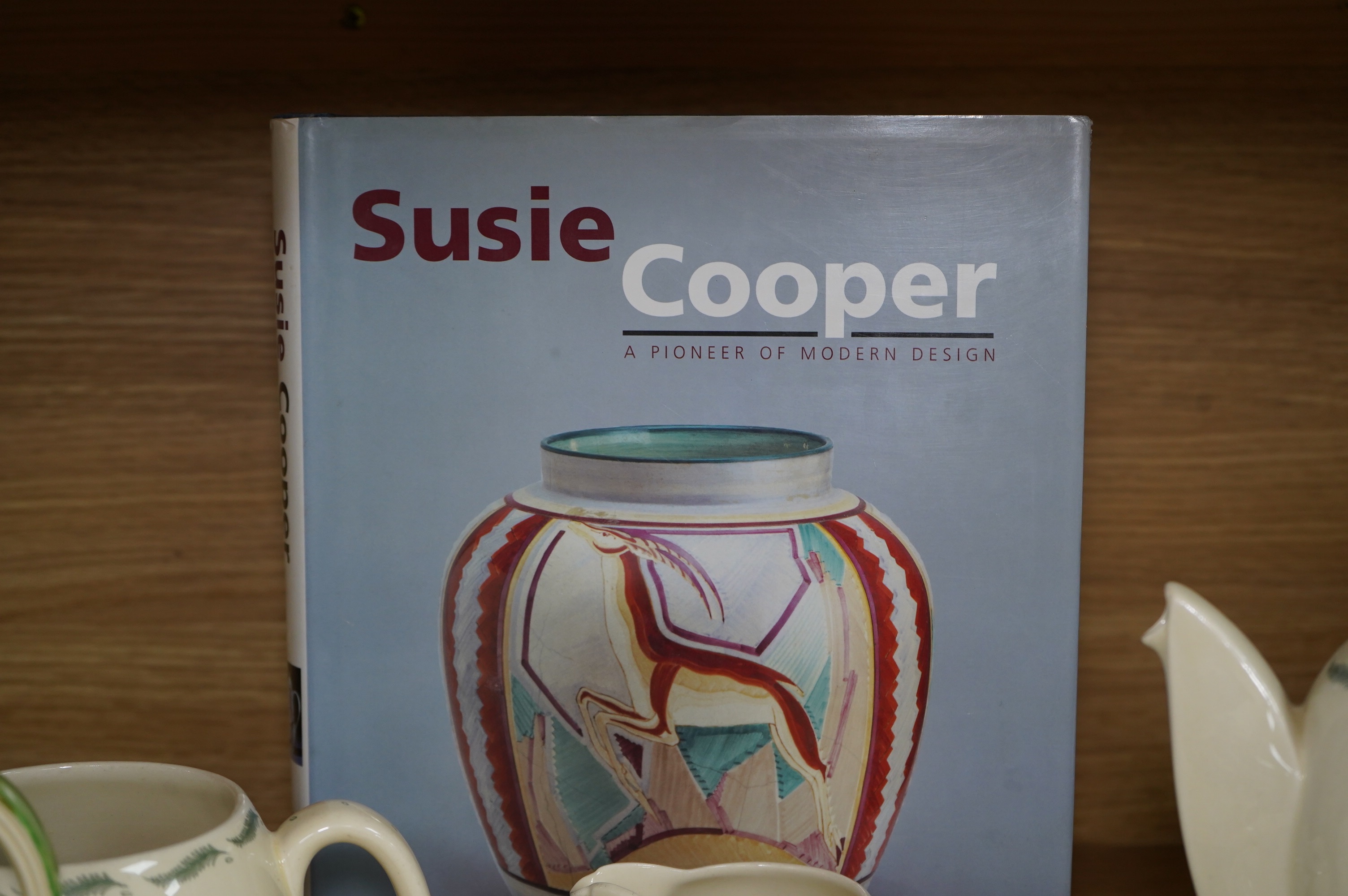 A Susie Cooper style 'Tiger Lily' pattern teaset, possibly by Wood & Co., a Susie Cooper reference book and a later painted Falcon shape coffee pot. Condition - good